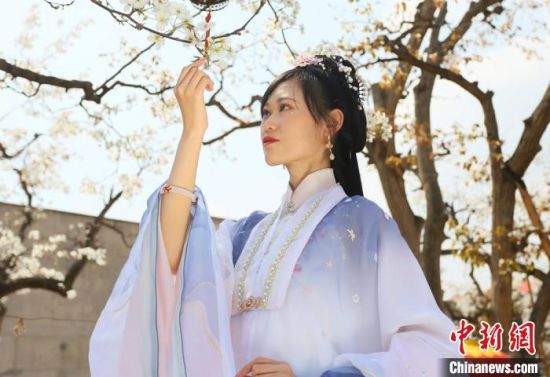 圖為蘭州青年身穿漢服在百年梨園賞景?！「哒?攝