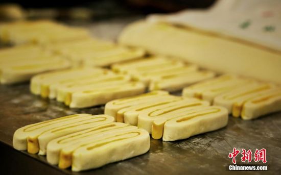 圖為面劑被涂上胡麻油，切成條狀用作月餅的花型制作。張文 攝