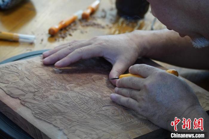 圖為徐晉林湊近木板，近距離制作雕版畫?！【琶赖┰?　攝