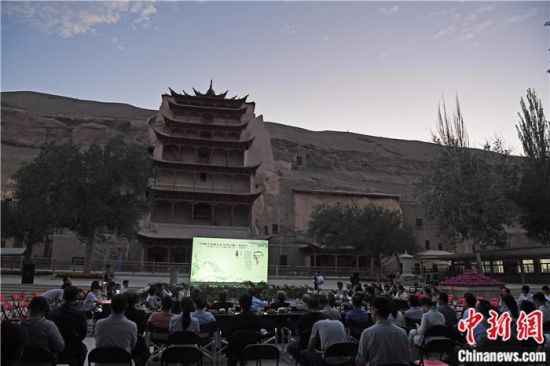 2018年8月，在敦煌莫高窟標(biāo)志性建筑“九層樓”前，《回顧平山郁夫先生的貢獻(xiàn)》座談會(huì)舉行。來自中日兩國的專家、學(xué)者共同懷念這位情系敦煌數(shù)十載的繪畫巨匠、中日友好的文化使者、世界文化遺產(chǎn)的守護(hù)者。中新社記者 楊艷敏 攝