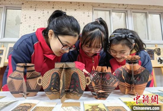 圖為學(xué)生用紙創(chuàng)作的立體彩陶?！⒂裉?攝