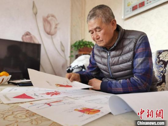 圖為陸鵬飛向記者展示多年帶隊(duì)的手寫筆記?！堟?攝