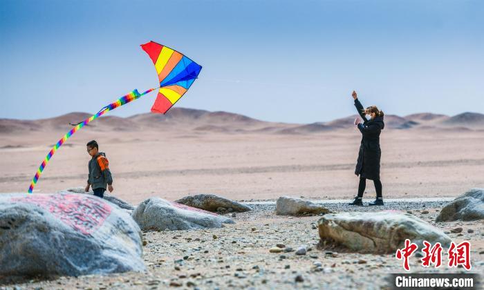 圖為市民正在陽關(guān)景區(qū)放風(fēng)箏。　王斌銀 攝