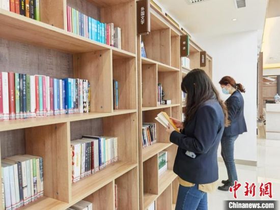 圖為在甘肅公航旅建設(shè)集團有限公司的職工書屋，職工挑選書籍?！⌒煅?攝