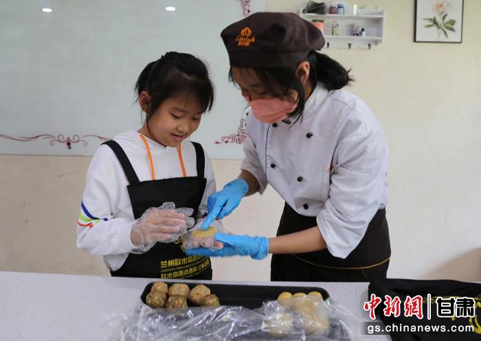 圖為在甘臺(tái)胞小朋友在工作人員指導(dǎo)下制作月餅。九美旦增 攝