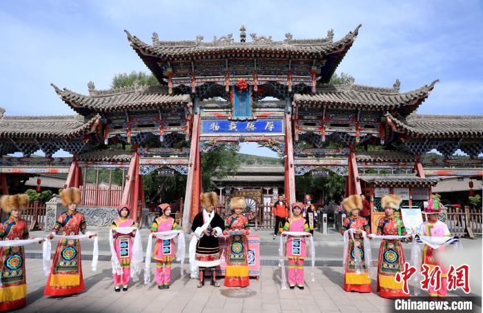 圖為身穿土族服飾的工作人員迎接訪客?！⊙Φ?攝