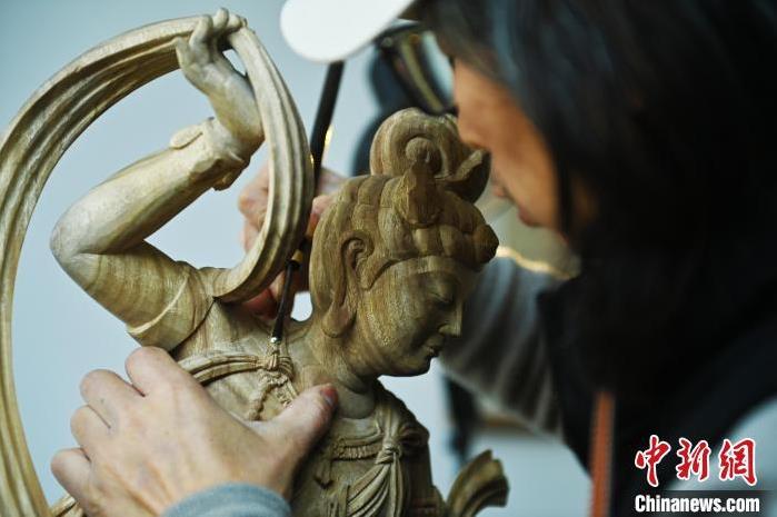 圖為季茂杰進行敦煌元素的木雕創(chuàng)作。李亞龍 攝</p>
<p>