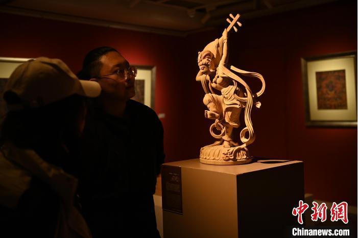 圖為季茂杰向參觀者介紹自己創(chuàng)作敦煌木雕的過程。李亞龍 攝</p>
<p>