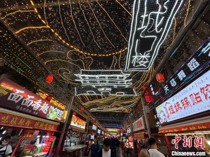 圖為明清街夜市燈光點(diǎn)亮具有武威文化元素的“涼州古城門”彩燈?！〈魑牟?攝</p><p>