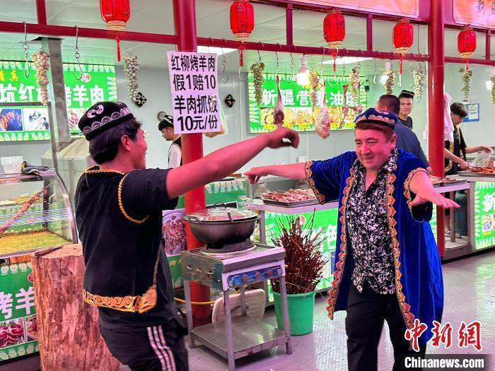 圖為餐飲經(jīng)營(yíng)者在“西涼不夜城”跳起舞蹈引客?！〈魑牟?攝</p><p>