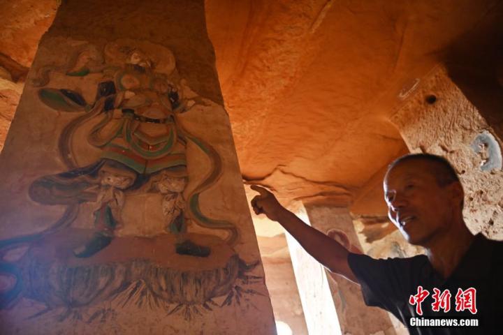 7月15日，甘肅省平?jīng)鍪袥艽h百里石窟長廊羅漢洞石窟內(nèi)，該窟文保員郭建平介紹窟內(nèi)石刻彩繪壁畫。郭建平家中三代人曾自發(fā)保護(hù)羅漢洞石窟。羅漢洞石窟遺存40余個窟龕，以北魏至清代風(fēng)格為主。中新社記者 李亞龍 攝</p>
<p>