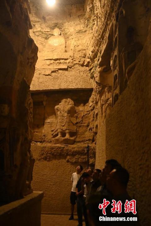 7月15日，游人參觀甘肅省平?jīng)鍪袥艽h百里石窟長廊中的王母宮石窟。百里石窟長廊位于涇川縣境內(nèi)，由512個石窟、5眼窟中石井組成，現(xiàn)存王母宮石窟、鳳凰山石窟、南石窟寺、丈八寺石窟、羅漢洞石窟、太山寺石窟等規(guī)模較大的石窟群，還有數(shù)量眾多的小石窟群。王母宮石窟又名千佛洞，該窟設(shè)計宏大，造像生動，窟內(nèi)擁有造像數(shù)百尊，是較為珍貴的佛教文化遺存。中新社記者 李亞龍 攝</p>
<p>