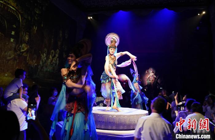 《樂動敦煌》是全球首部洞窟式沉浸體驗(yàn)劇，利用真人與數(shù)字影像虛實(shí)交換實(shí)現(xiàn)沉浸式體驗(yàn)。圖為2023年8月28日晚，《樂動敦煌》演出。(資料圖)中新社記者 毛建軍 攝