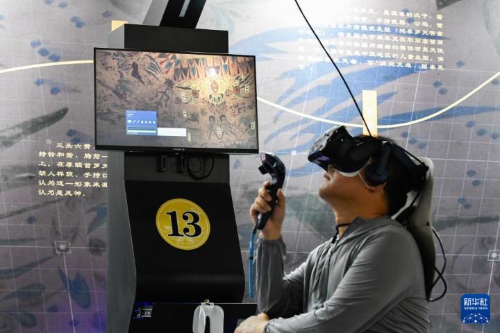 7月22日，游客借助VR設(shè)備沉浸式游覽莫高窟第285窟虛擬場景。新華社記者 郎兵兵 攝